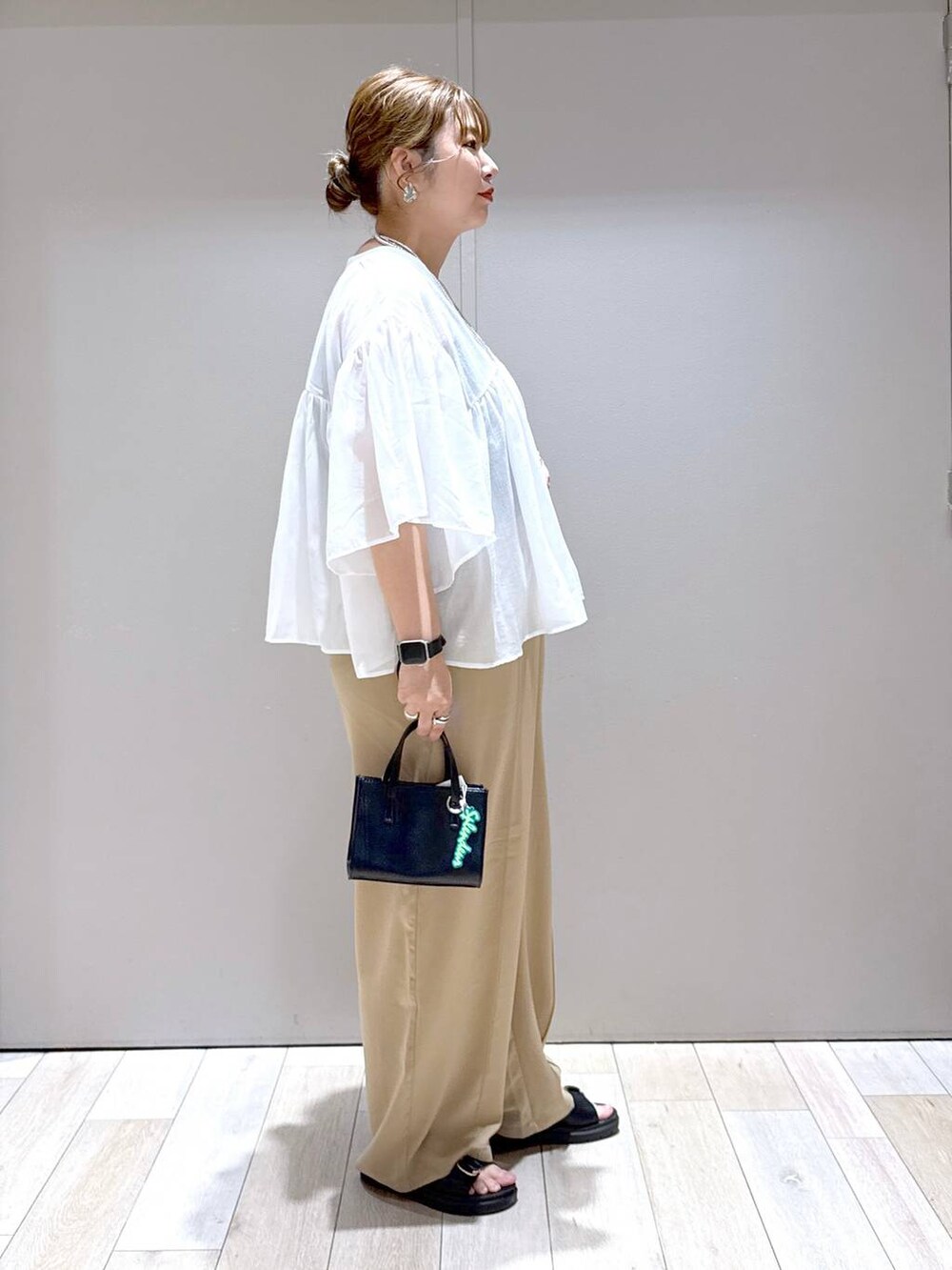 ベージュ系のその他パンツ、ホワイト系のシャツ/ブラウス、ブラック系のタンクトップを着用したレディースの春コーディネートの3枚目の写真