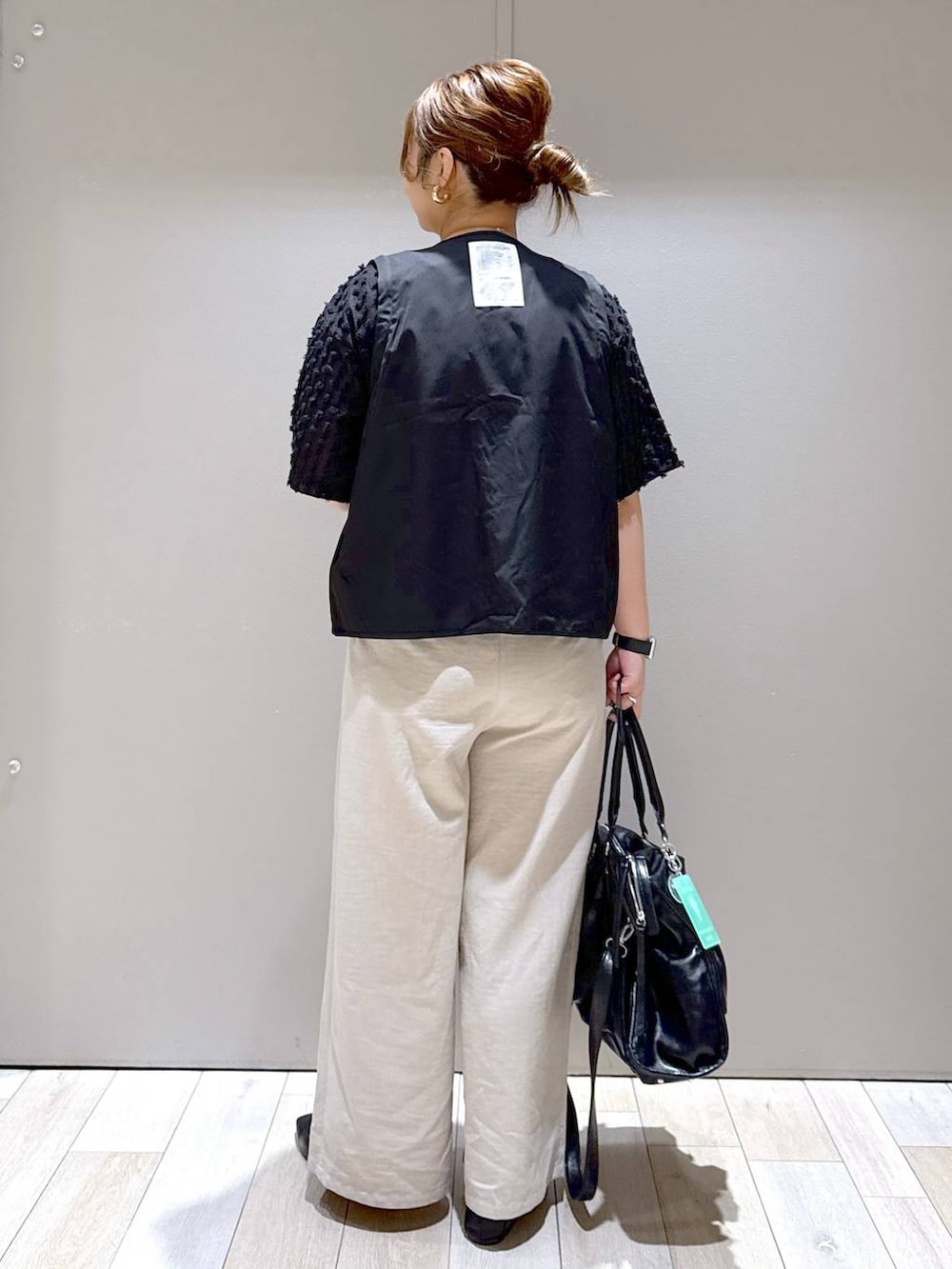 ブラック系のトートバッグ、ベージュ系のその他パンツ、ブラック系のローファーを着用したレディースの春コーディネートの3枚目の写真