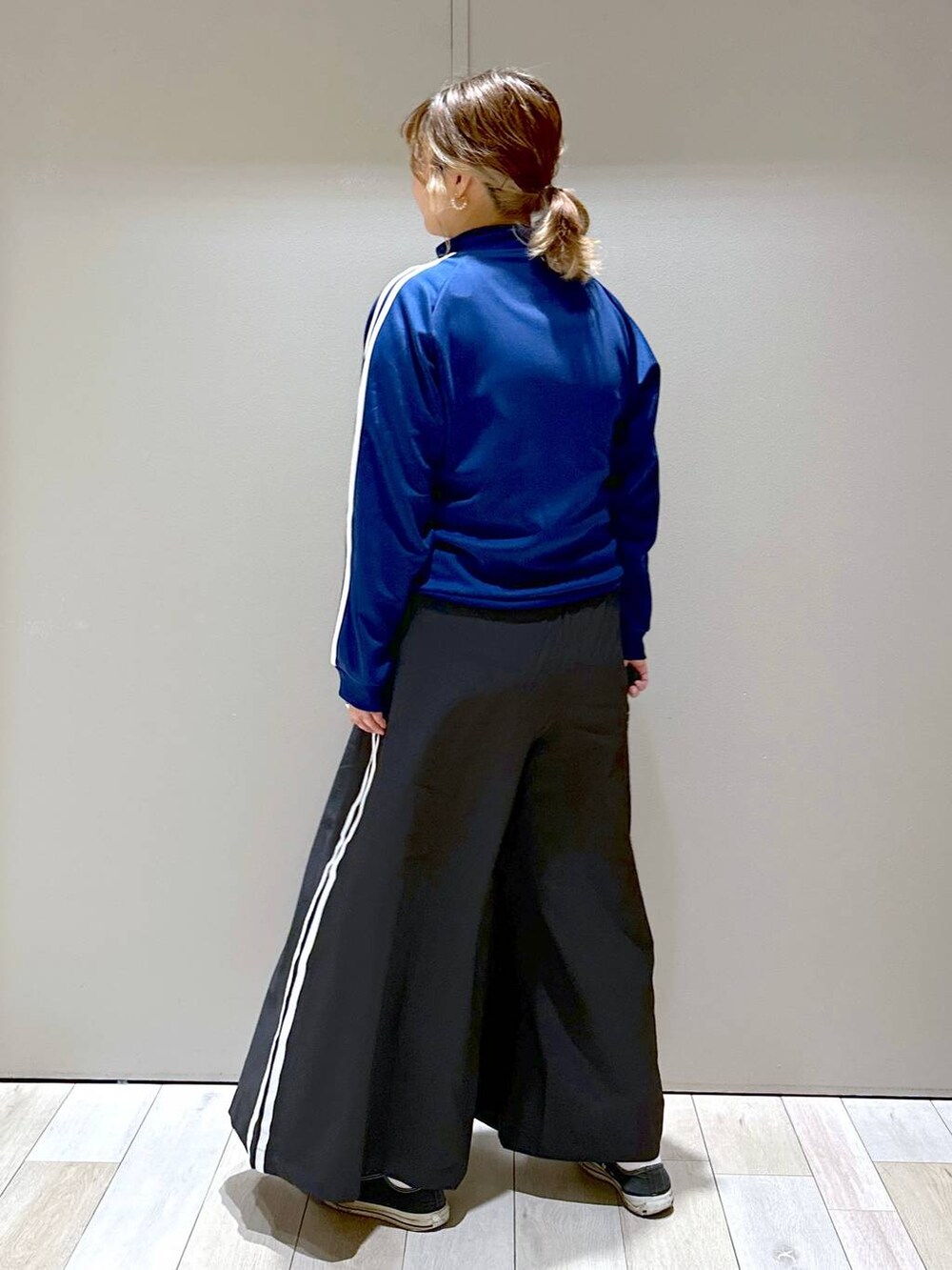 ブルー系のその他アウター、ブラック系のその他パンツ、ゴールド系のピアス(両耳用)を着用したレディースの秋コーディネートの3枚目の写真