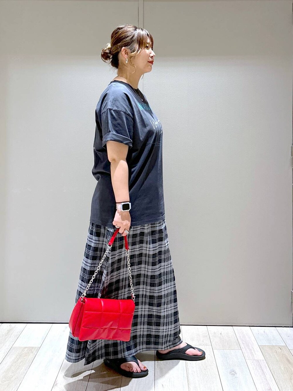 レッド系のショルダーバッグ、ブラック系のサンダル、グレー系のTシャツ/カットソーを着用したレディースの夏コーディネートの2枚目の写真