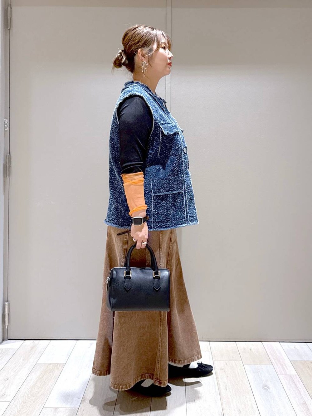 ブラック系のTシャツ/カットソー、ブラック系のパンプス、ブラック系のボストンバッグを着用したレディースの冬コーディネートの2枚目の写真