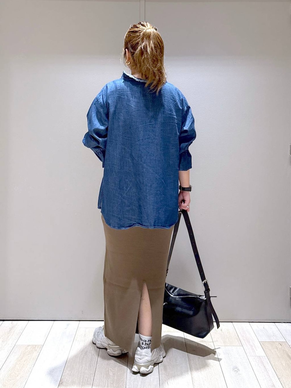 ブラウン系のスカート、ブラック系のショルダーバッグ、ブルー系のシャツ/ブラウスを着用したレディースの夏コーディネートの3枚目の写真