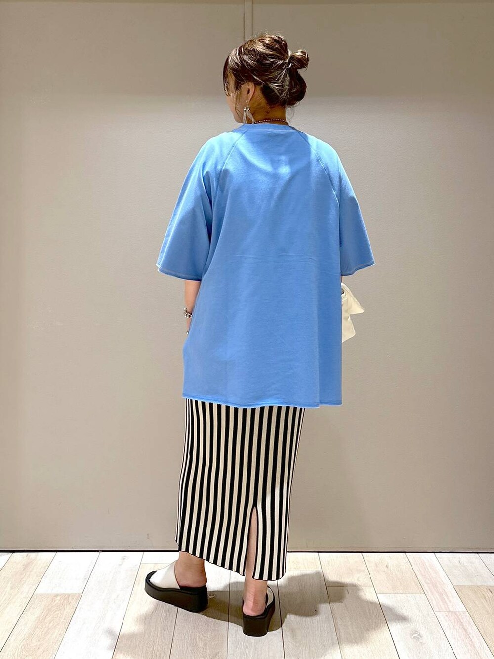 ホワイト系のショルダーバッグ、ブルー系のTシャツ/カットソー、ホワイト系のスカートを着用したレディースの春コーディネートの3枚目の写真