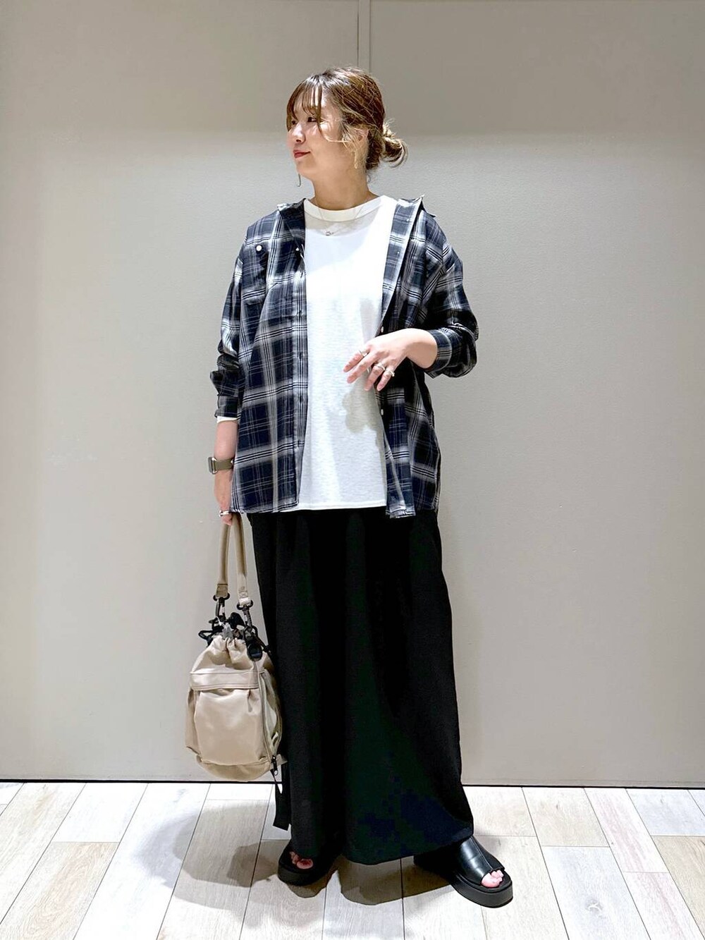 ホワイト系のTシャツ/カットソー、ブラック系のその他パンツ、ベージュ系のショルダーバッグを着用したレディースの春コーディネートの5枚目の写真