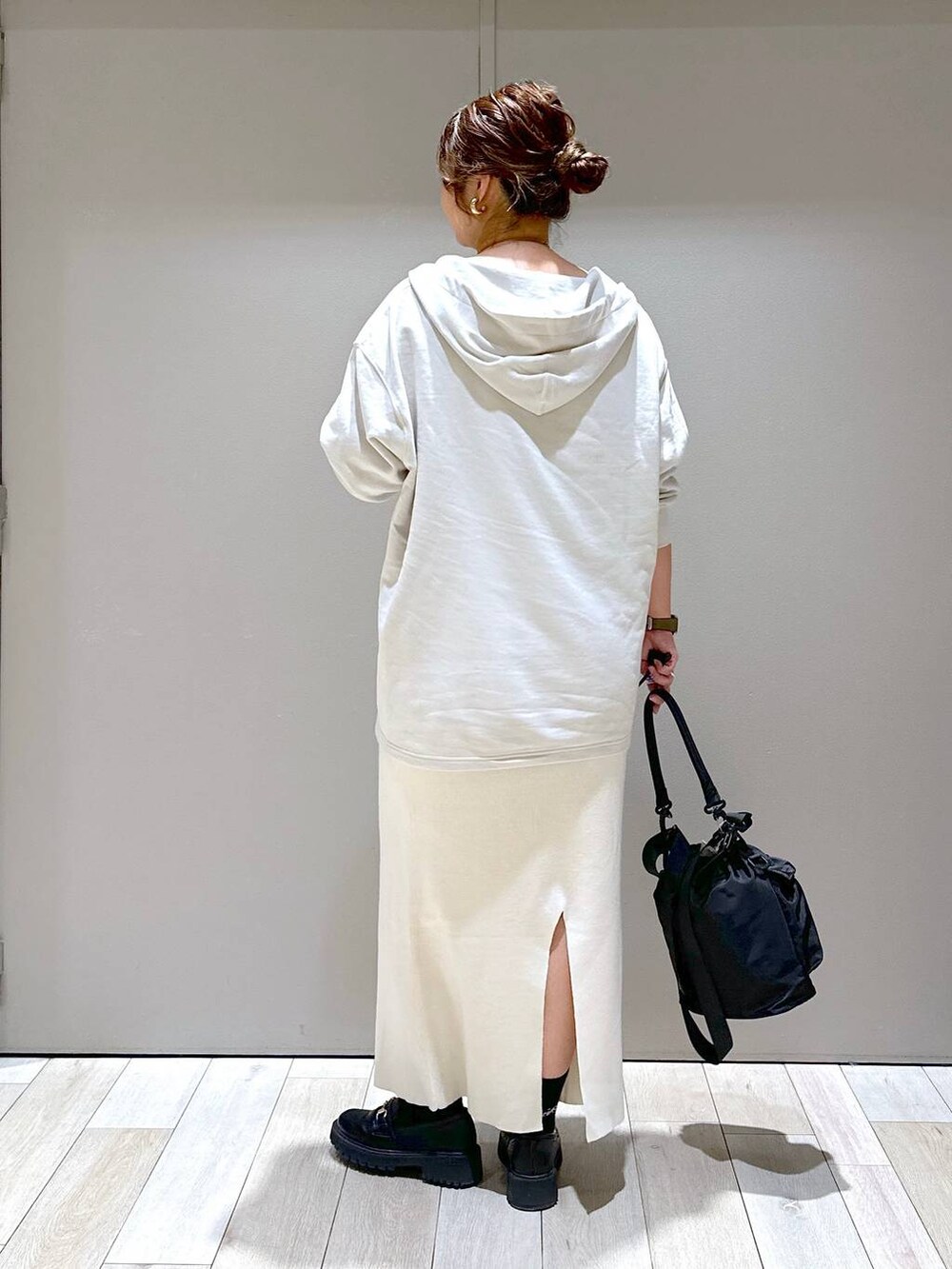 ブラック系のショルダーバッグ、ブラック系のローファー、ホワイト系のスカートを着用したレディースの秋コーディネートの3枚目の写真