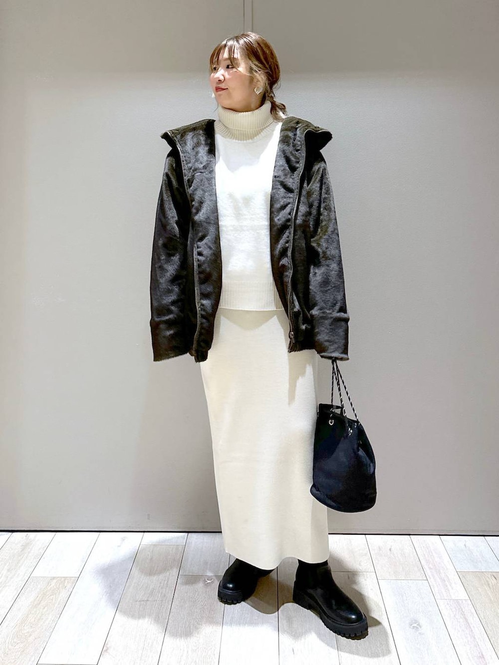 ホワイト系のニット/セーター、ホワイト系のスカート、グリーン系のブルゾンを着用したレディースの冬コーディネートの5枚目の写真