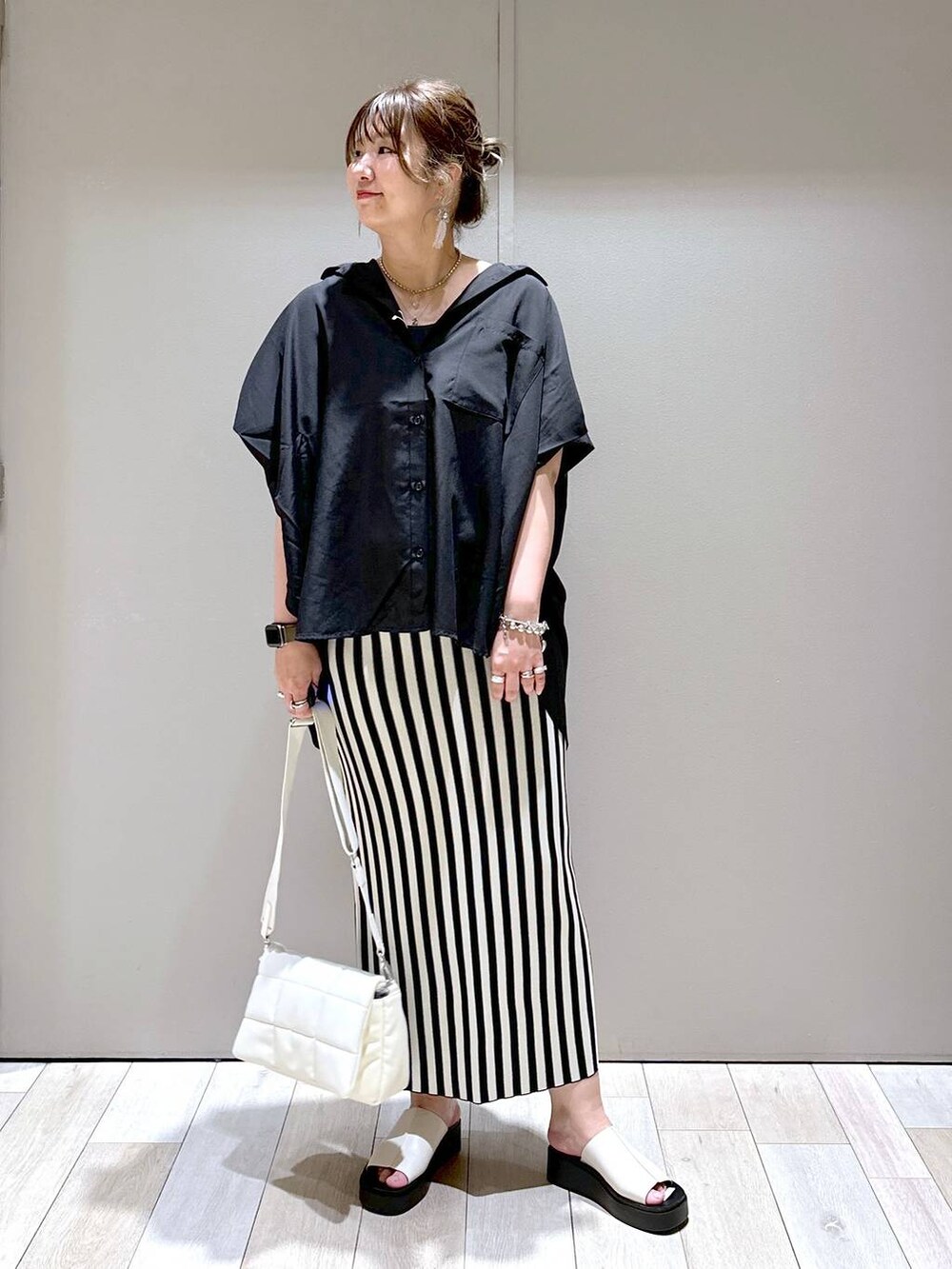 ホワイト系のショルダーバッグ、ブラック系のシャツ/ブラウス、ホワイト系のスカートを着用したレディースの春コーディネートの5枚目の写真