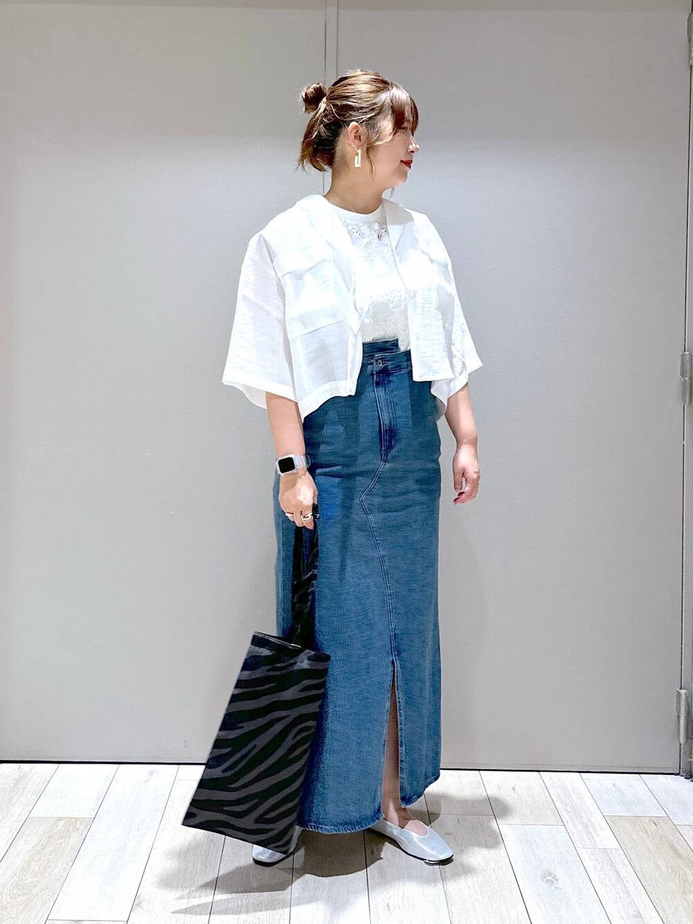 ホワイト系のシャツ/ブラウス、グレー系のトートバッグ、シルバー系のパンプスを着用したレディースの夏コーディネートの3枚目の写真