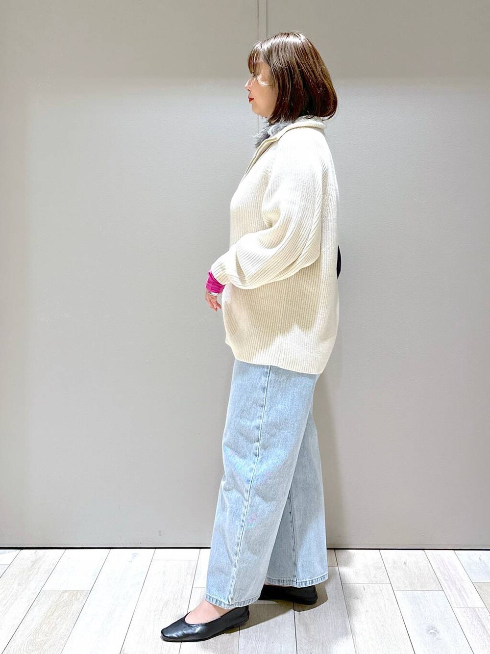 ホワイト系のニット/セーター、ブルー系のデニムパンツ、ブルー系のショルダーバッグを着用したレディースの冬コーディネートの2枚目の写真