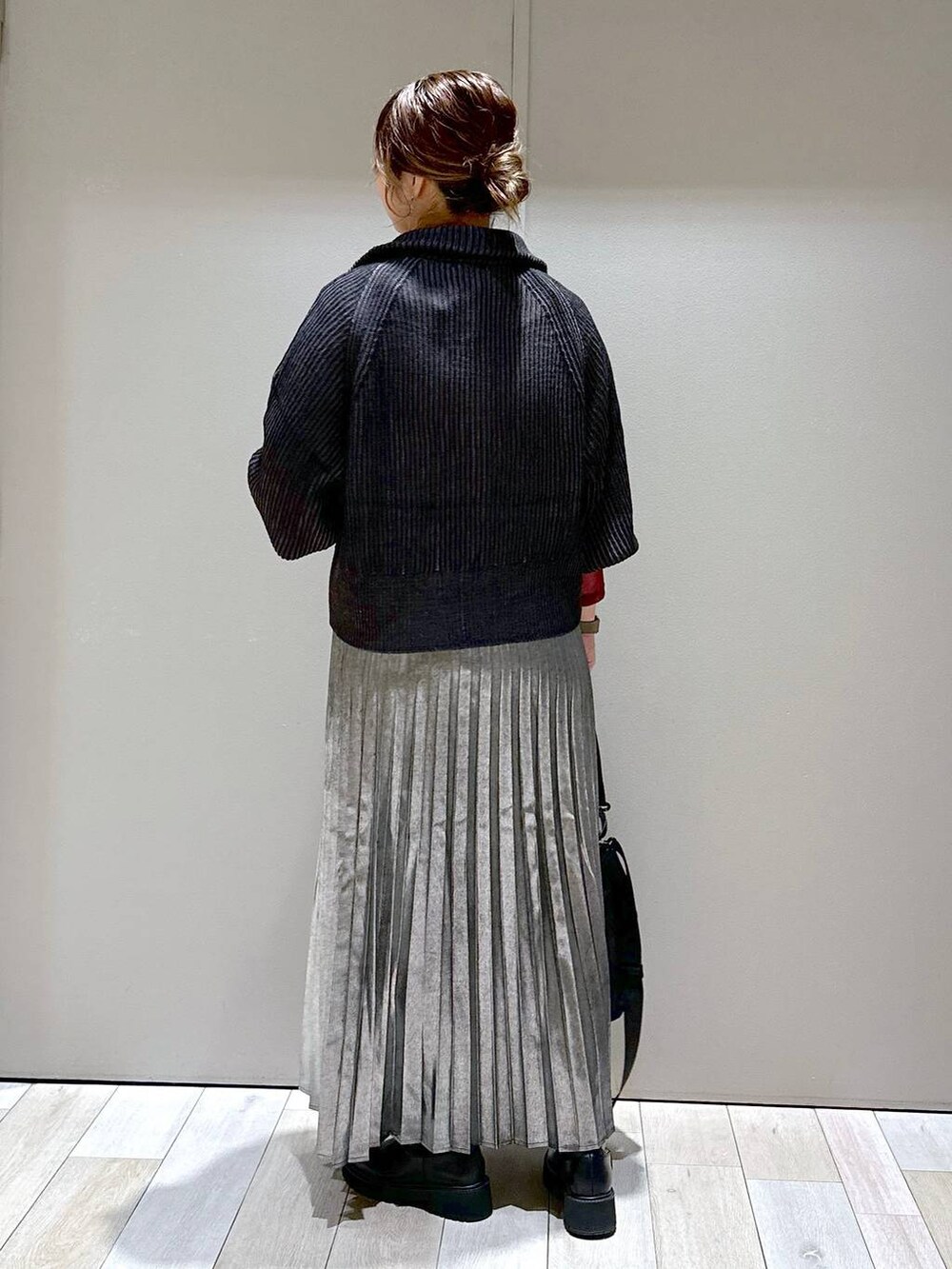 ブラック系のショルダーバッグ、ブラック系のカーディガン/ボレロ、ブラック系のブーツを着用したレディースの秋コーディネートの3枚目の写真