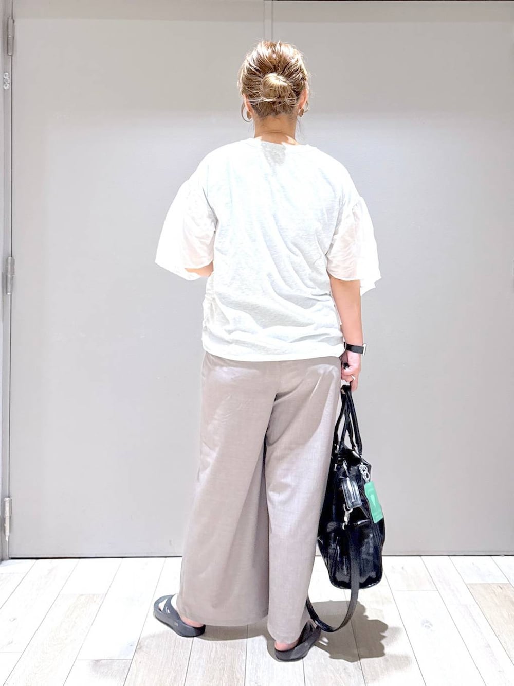 ブラック系のトートバッグ、ベージュ系のその他パンツ、ブラック系のサンダルを着用したレディースの春コーディネートの3枚目の写真