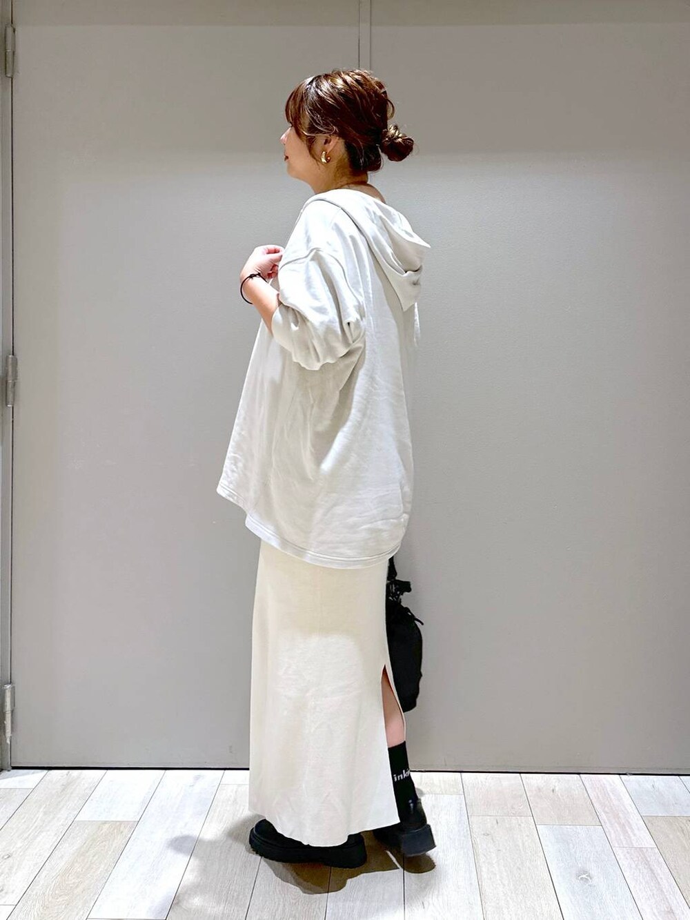 ブラック系のショルダーバッグ、ブラック系のローファー、ホワイト系のスカートを着用したレディースの秋コーディネートの5枚目の写真