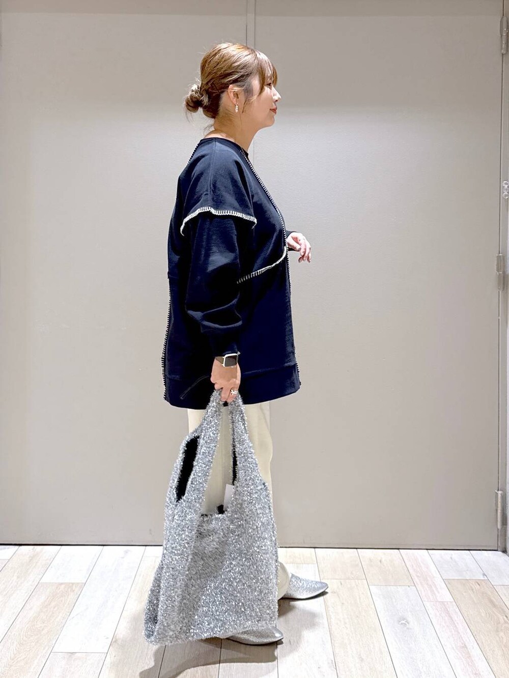 シルバー系のショルダーバッグ、グレー系のパンプス、ブラック系のワンピースを着用したレディースの冬コーディネートの2枚目の写真