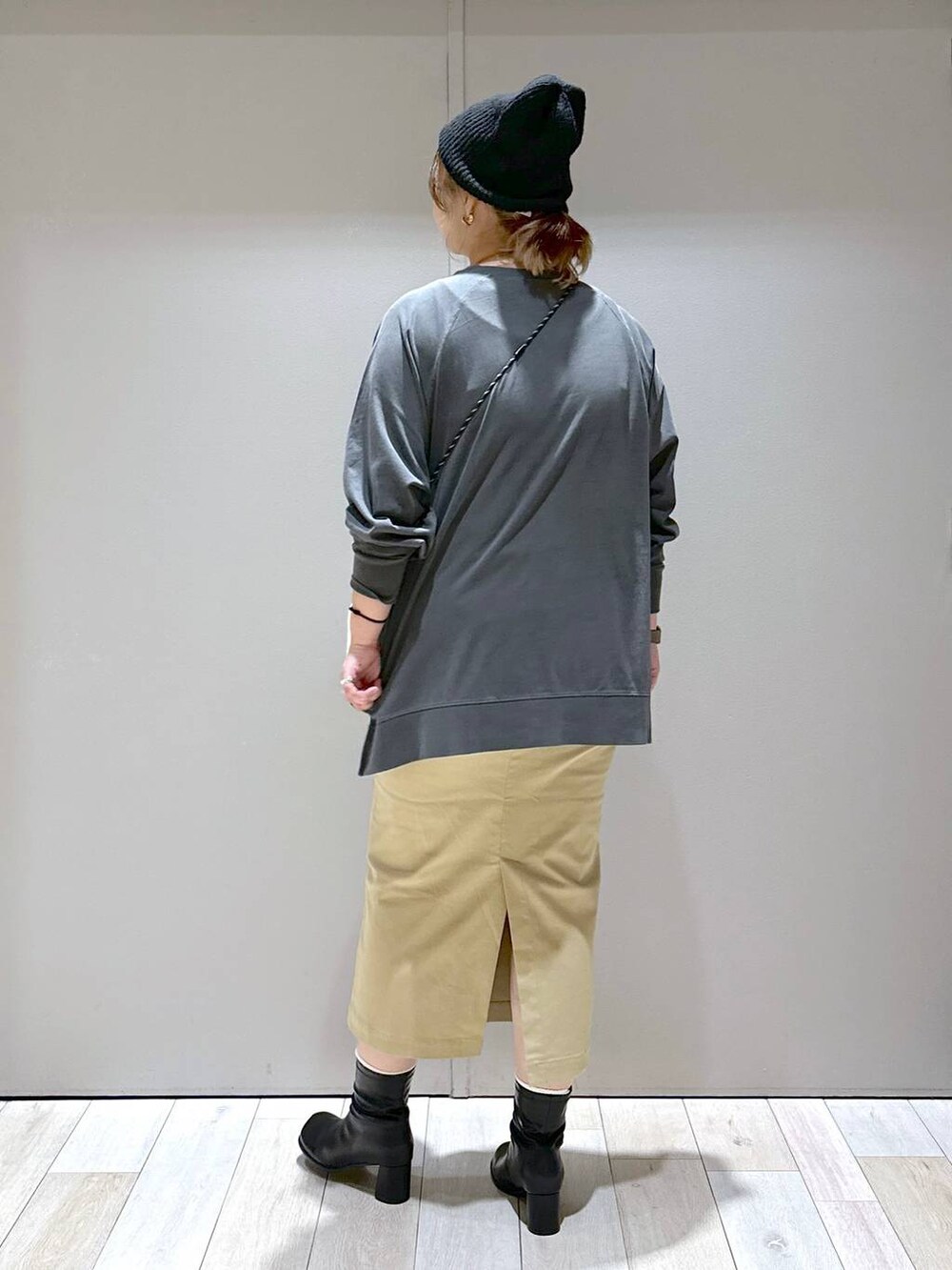 グレー系のTシャツ/カットソー、ブラック系のブーツ、ブラック系のニットキャップ/ビーニーを着用したレディースの秋コーディネートの3枚目の写真