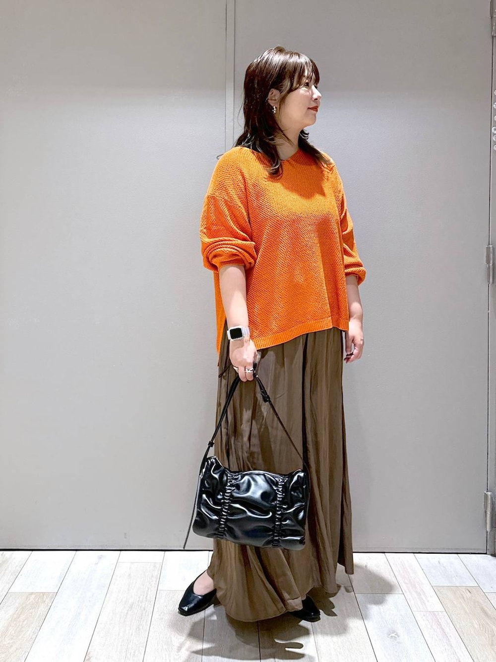 ブラック系のショルダーバッグ、オレンジ系のニット/セーター、ブラウン系のその他パンツを着用したレディースの秋コーディネートの5枚目の写真