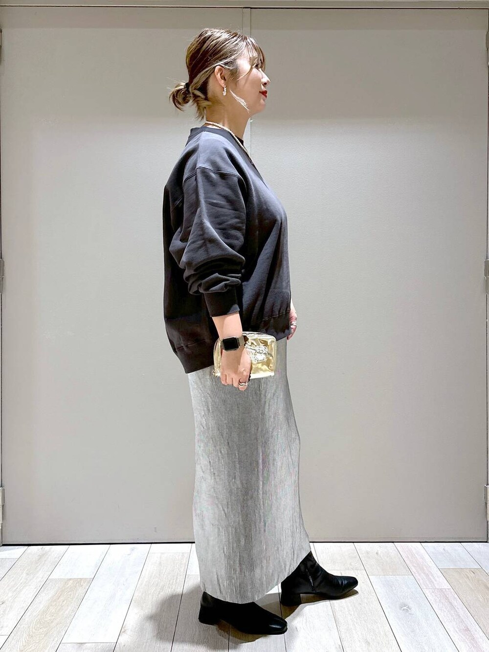 ブラック系のブーツ、シルバー系のスカート、グレー系のスウェットを着用したレディースの秋コーディネートの2枚目の写真