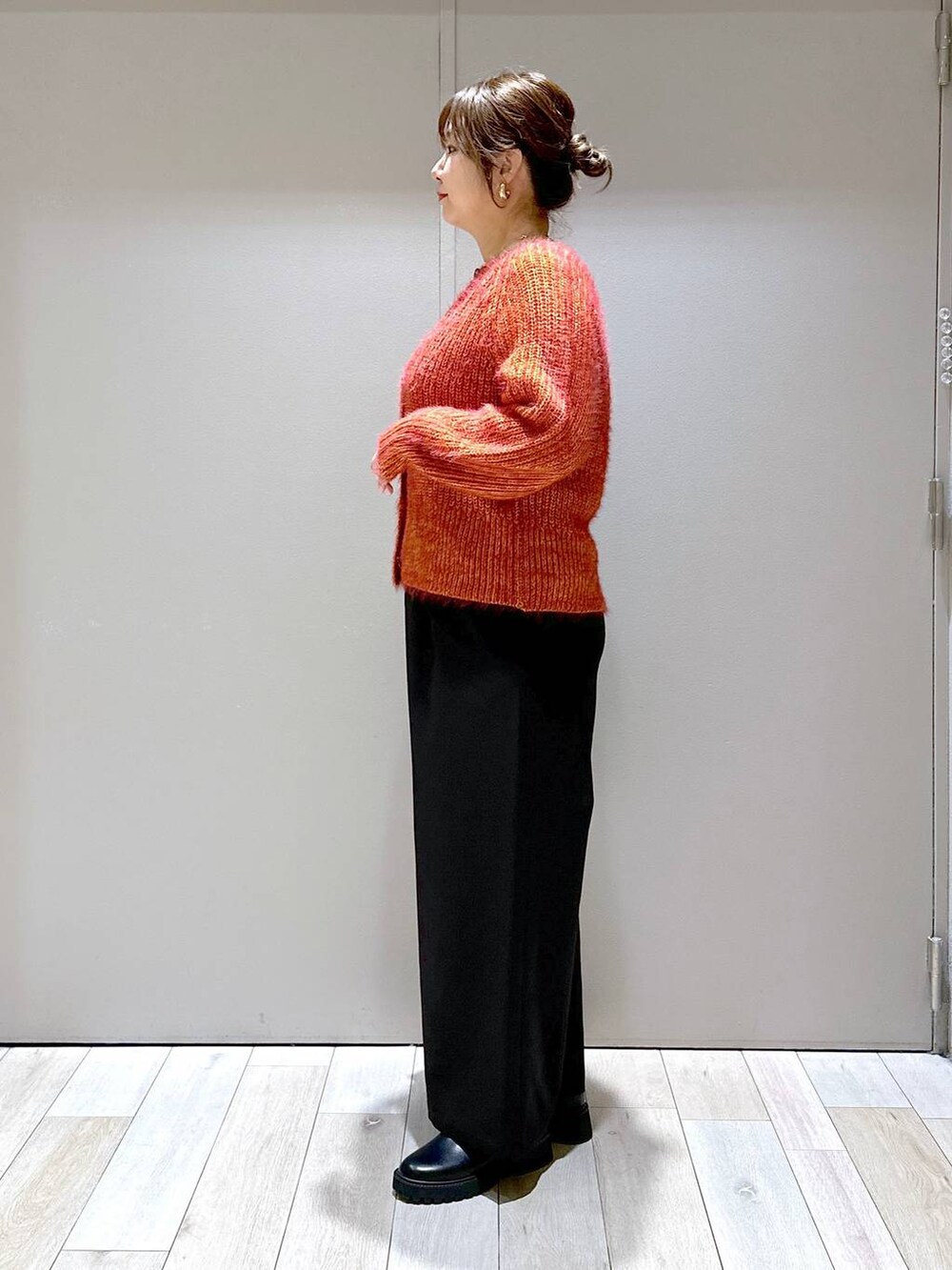 ブラック系のその他パンツ、レッド系のカーディガン/ボレロ、ブラック系のブーツを着用したレディースの秋コーディネートの4枚目の写真