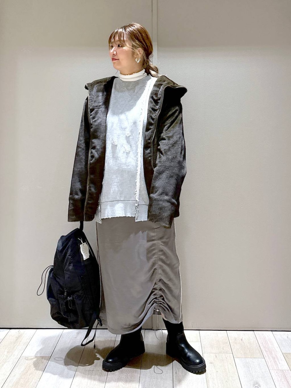 ホワイト系のTシャツ/カットソー、ブラック系のブーツ、グリーン系のブルゾンを着用したレディースの冬コーディネートの5枚目の写真