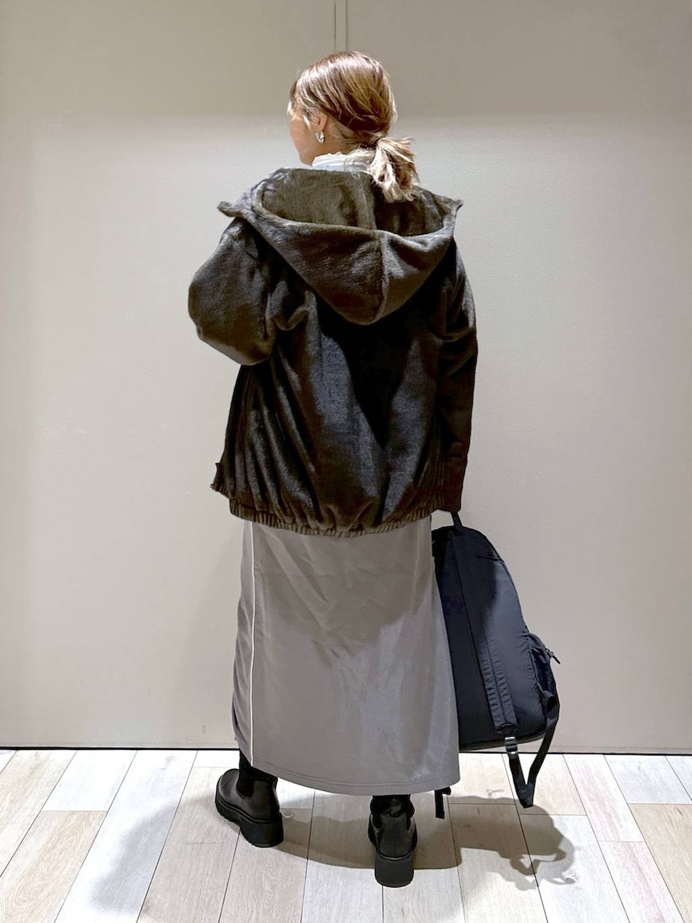 ホワイト系のTシャツ/カットソー、ブラック系のブーツ、グリーン系のブルゾンを着用したレディースの冬コーディネートの4枚目の写真