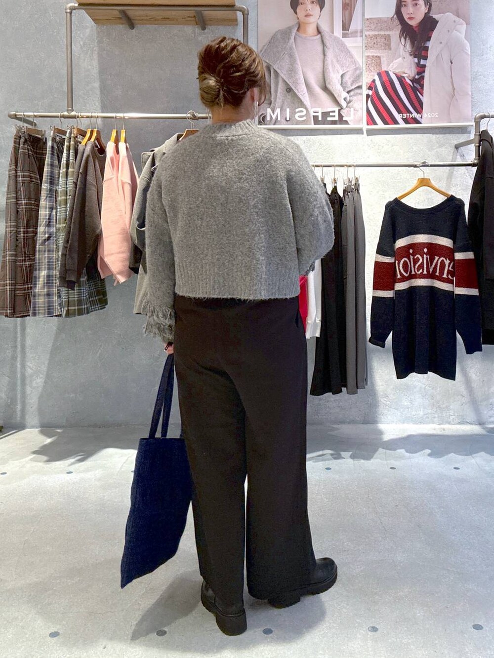 ブルー系のトートバッグ、ブラック系のその他パンツ、ブラック系のブーツを着用したレディースの冬コーディネートの3枚目の写真