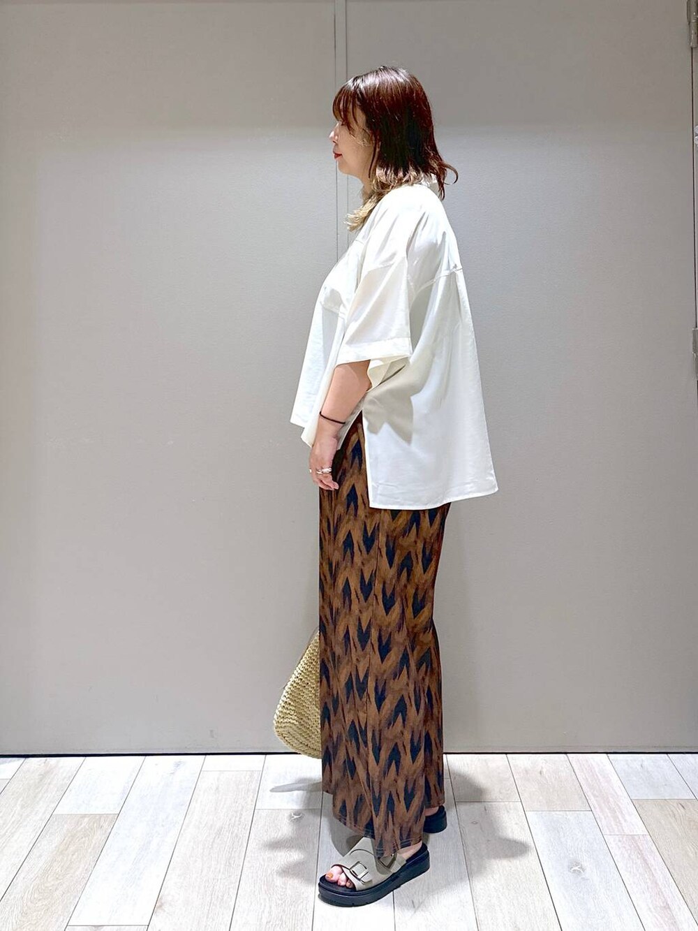 ベージュ系のショルダーバッグ、ホワイト系のシャツ/ブラウス、ベージュ系のサンダルを着用したレディースの夏コーディネートの4枚目の写真