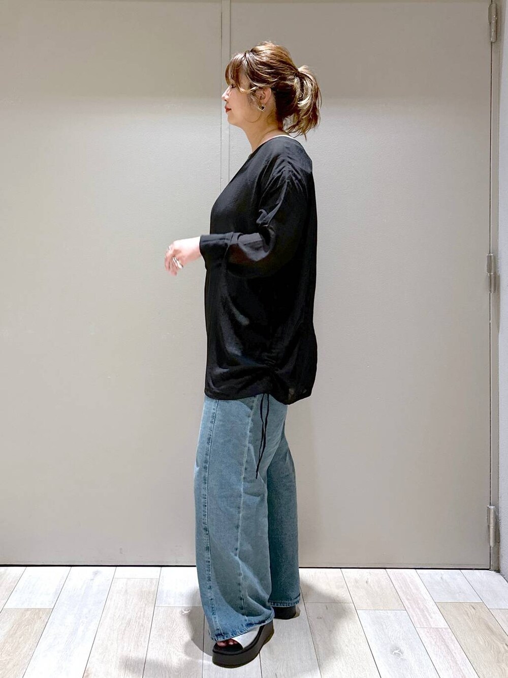 シルバー系のショルダーバッグ、ブルー系のデニムパンツ、シルバー系のサンダルを着用したレディースの秋コーディネートの4枚目の写真