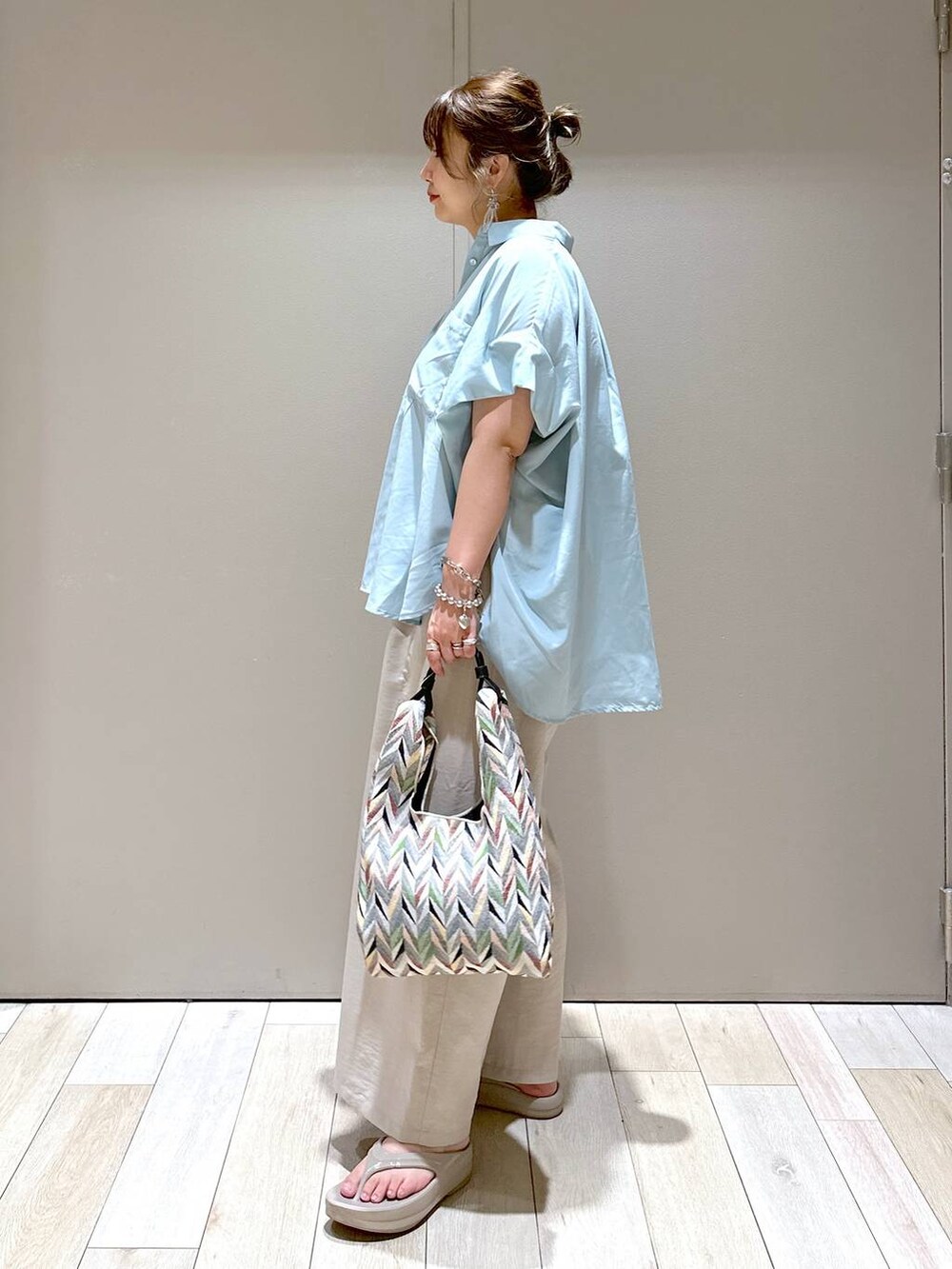 ベージュ系のその他パンツ、ホワイト系のハンドバッグ、ベージュ系のサンダルを着用したレディースの春コーディネートの4枚目の写真