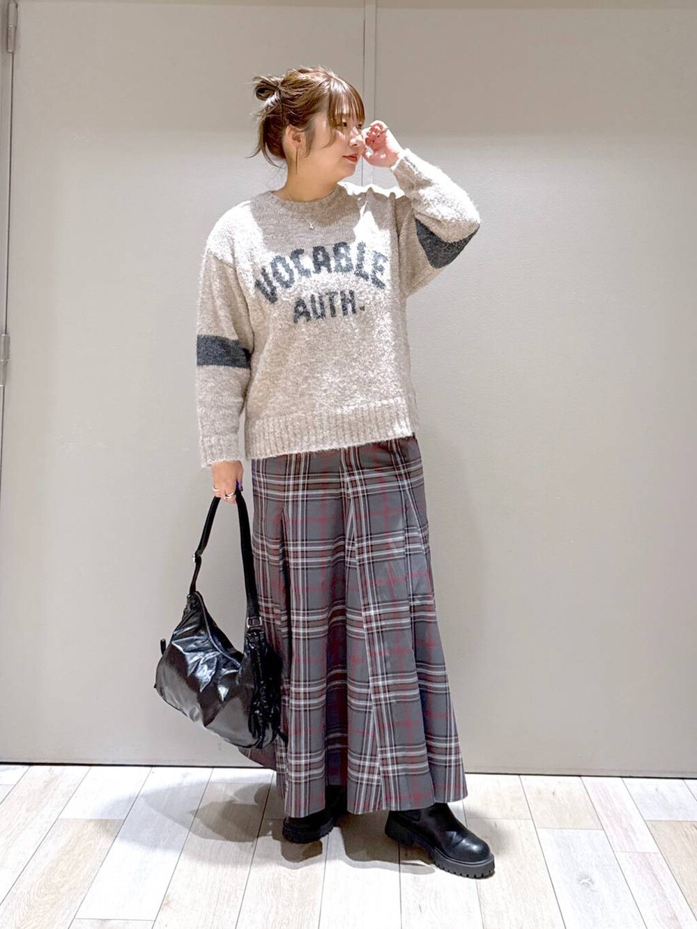 グレー系のスカート、ブラック系のブーツ、ブラック系のショルダーバッグを着用したレディースの冬コーディネートの5枚目の写真