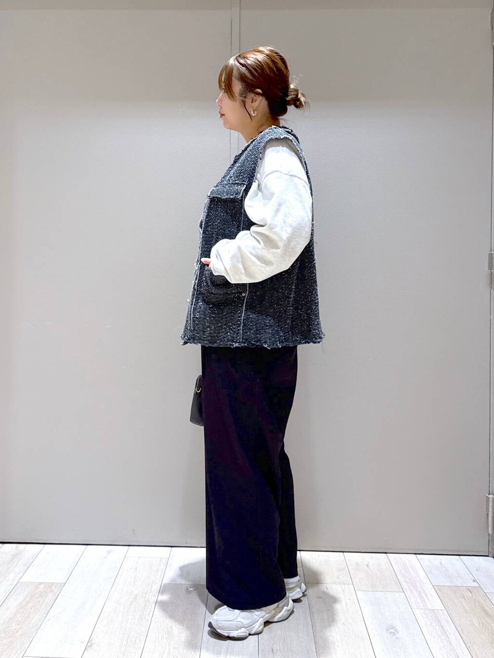 オレンジ系のTシャツ/カットソー、ブラック系のボストンバッグ、ブラック系のその他パンツを着用したレディースの冬コーディネートの4枚目の写真