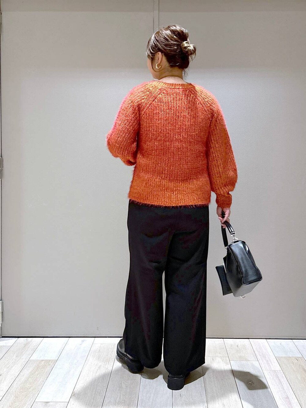 ブラック系のその他パンツ、レッド系のカーディガン/ボレロ、ブラック系のブーツを着用したレディースの秋コーディネートの2枚目の写真