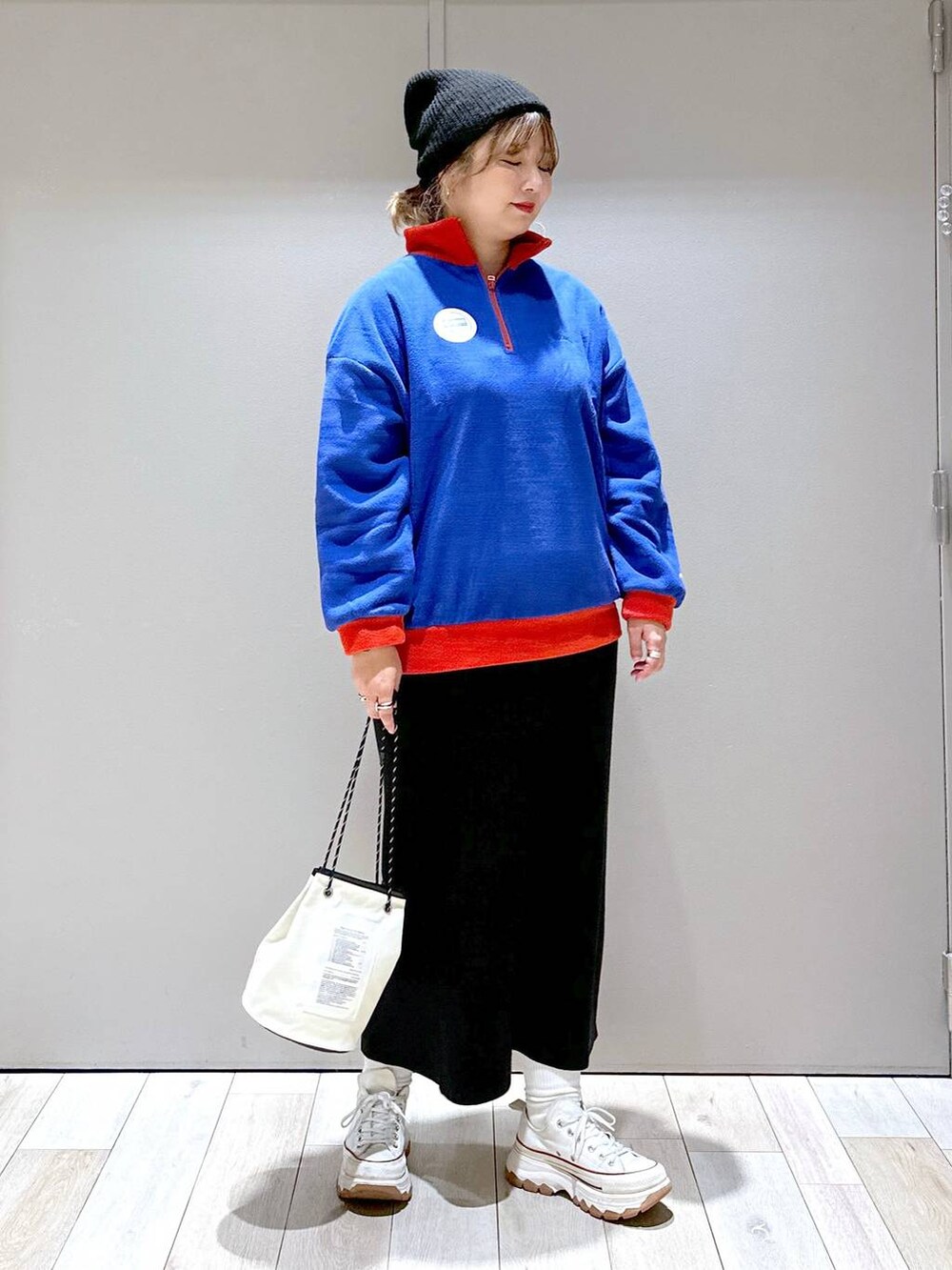 ブラック系のスカート、ブルー系のTシャツ/カットソー、ブラック系のニットキャップ/ビーニーを着用したレディースの秋コーディネートの4枚目の写真