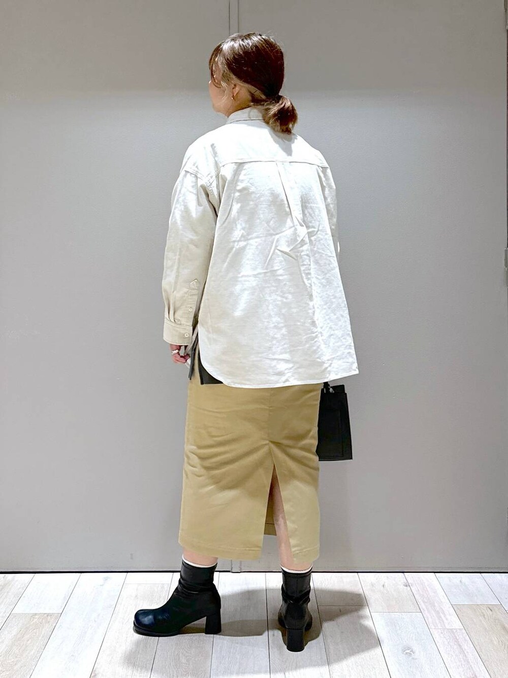 グレー系のTシャツ/カットソー、ホワイト系のシャツ/ブラウス、ブラック系のショルダーバッグを着用したレディースの秋コーディネートの3枚目の写真