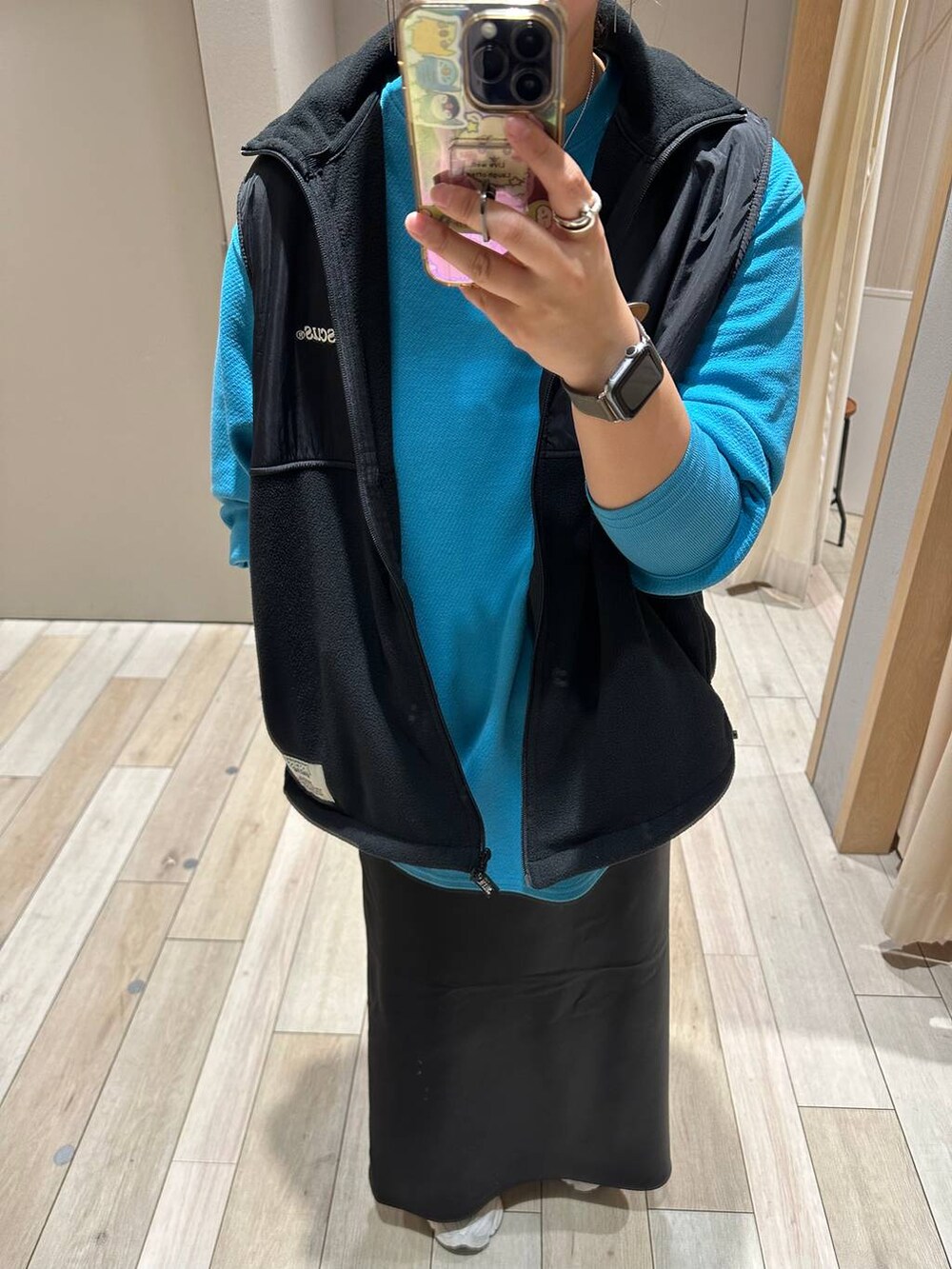 ブルー系のTシャツ/カットソー、ブラック系のベスト、ブラック系のスカートを着用したレディースの秋コーディネートの2枚目の写真