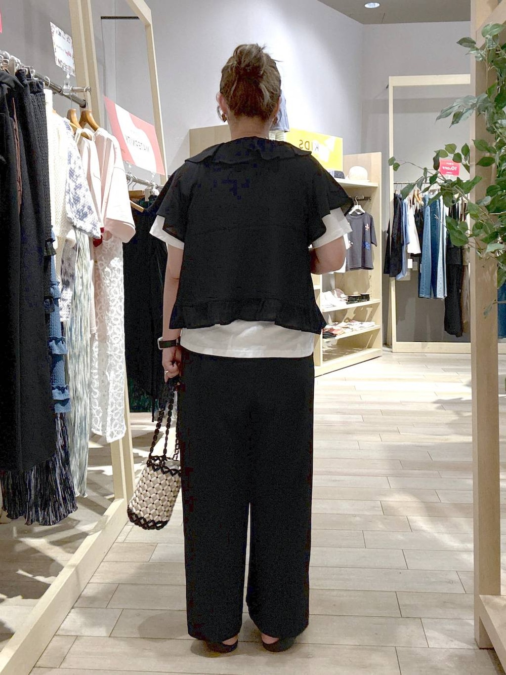 ブラック系のその他パンツ、ホワイト系のハンドバッグ、ブラック系のシャツ/ブラウスを着用したレディースの夏コーディネートの3枚目の写真