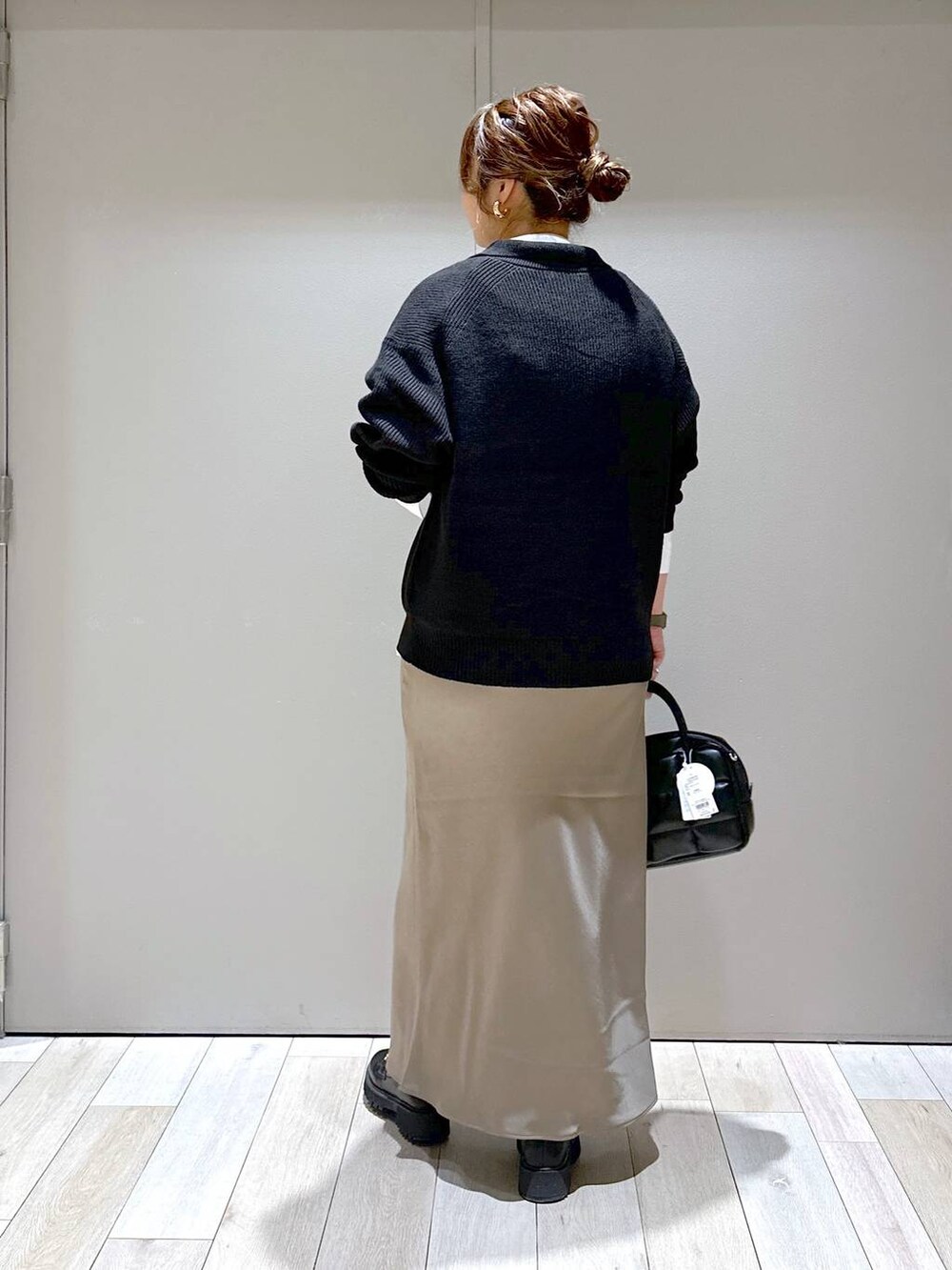 ブラック系のローファー、ブラック系のカーディガン/ボレロ、ブラウン系のスカートを着用したレディースの秋コーディネートの3枚目の写真