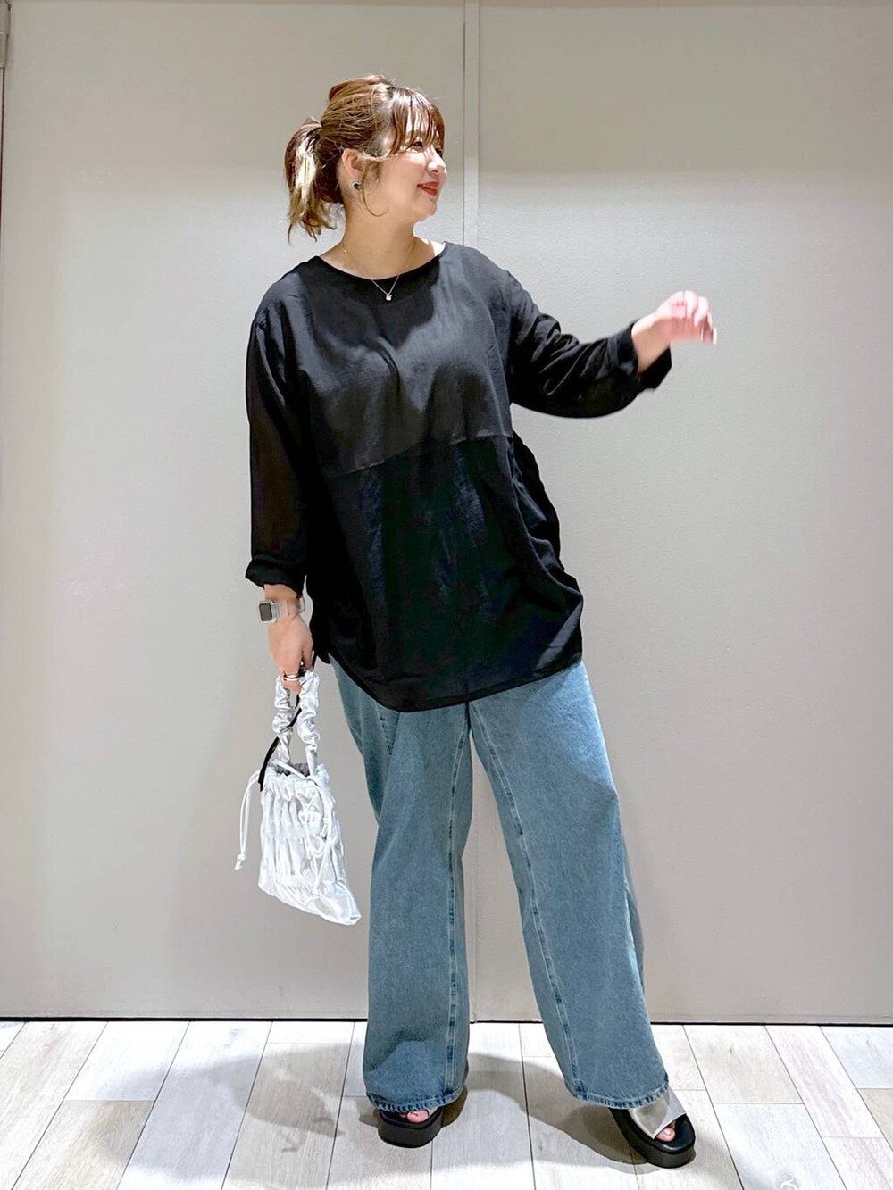 シルバー系のショルダーバッグ、ブルー系のデニムパンツ、シルバー系のサンダルを着用したレディースの秋コーディネートの5枚目の写真