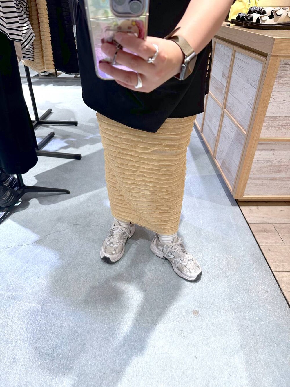 ベージュ系のスカート、ブラック系のTシャツ/カットソーを着用したレディースの春コーディネートの3枚目の写真