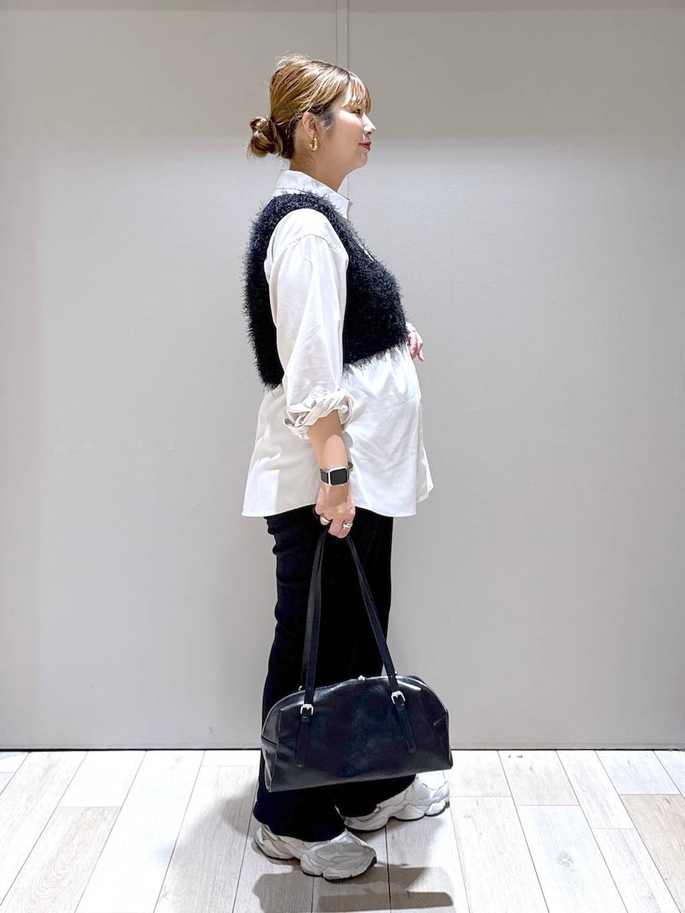 ベージュ系のシャツ/ブラウス、ブラック系のベスト、ブラック系のボストンバッグを着用したレディースの秋コーディネートの2枚目の写真