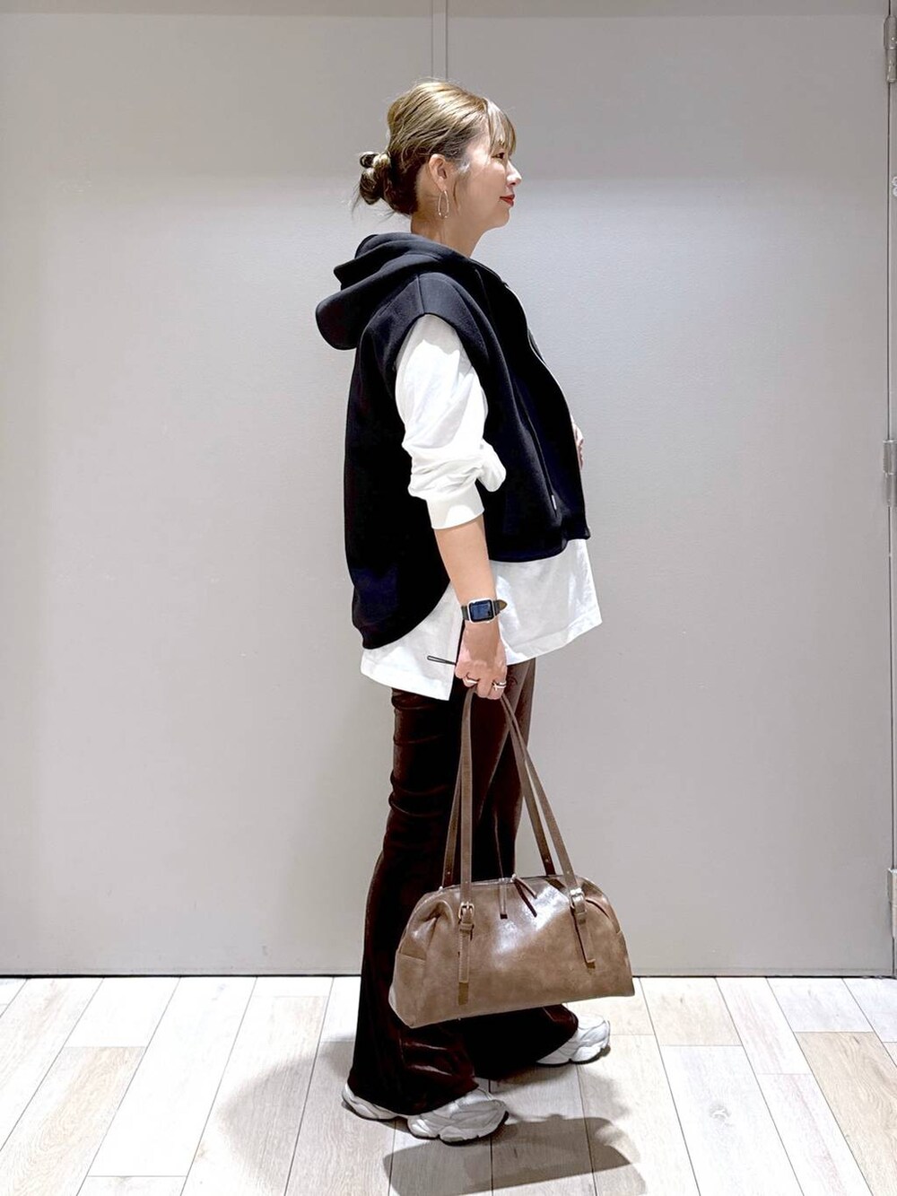 ブラウン系のその他パンツ、ブラウン系のボストンバッグ、ブラック系のベストを着用したレディースの秋コーディネートの2枚目の写真