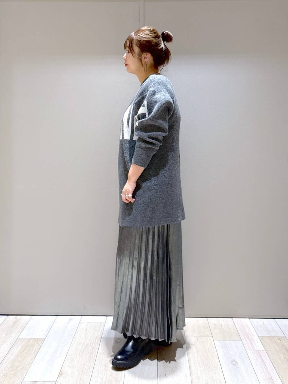 ブラック系のショルダーバッグ、ブラック系のブーツ、グレー系のスカートを着用したレディースの冬コーディネートの5枚目の写真