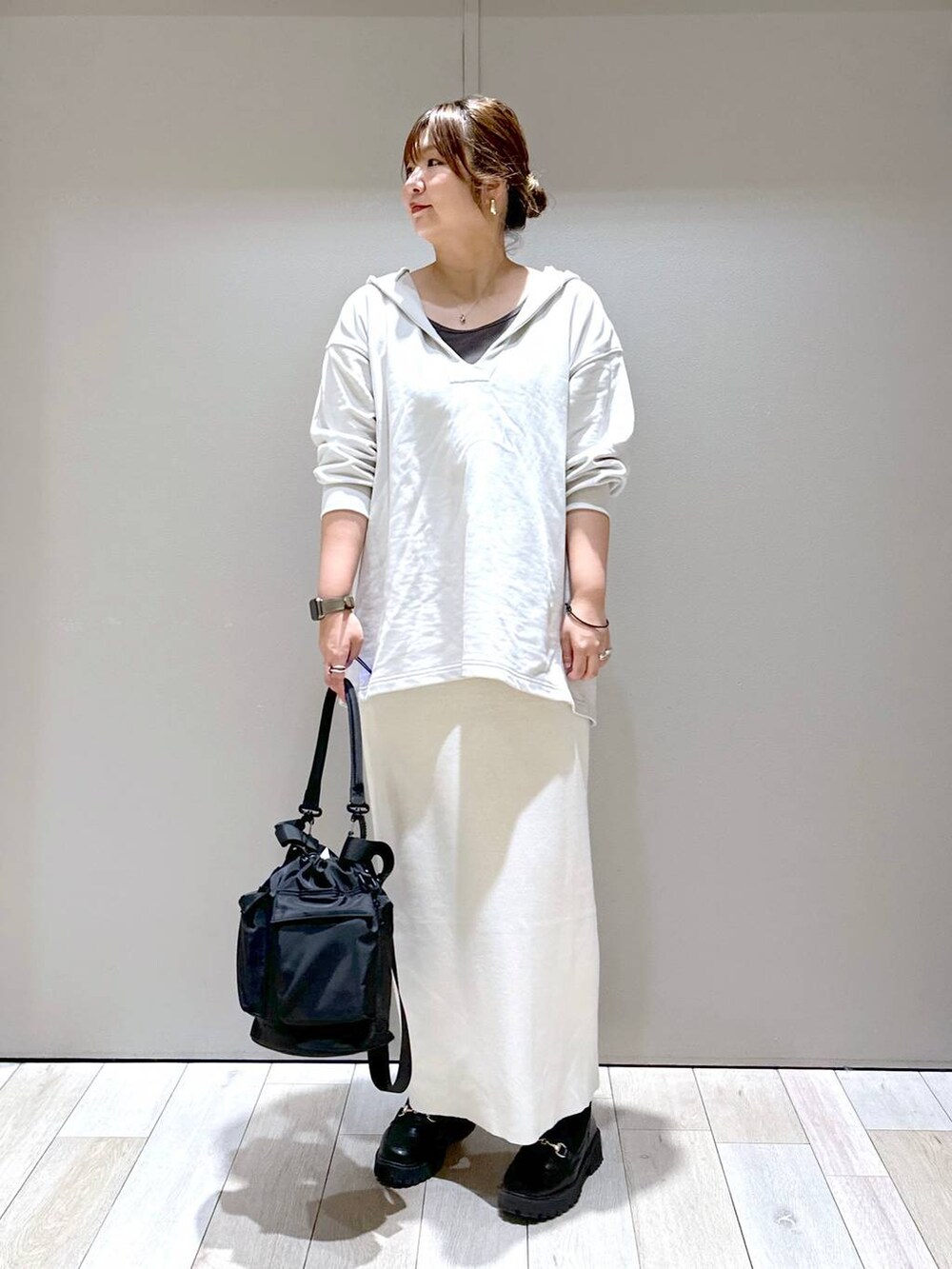 ブラック系のショルダーバッグ、ブラック系のローファー、ホワイト系のスカートを着用したレディースの秋コーディネートの6枚目の写真