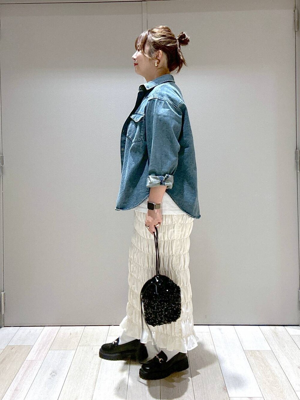 ホワイト系のスカート、ブラック系のローファー、ブラック系のショルダーバッグを着用したレディースの秋コーディネートの4枚目の写真