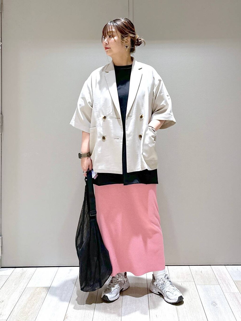 ブラック系のショルダーバッグ、ベージュ系のテーラードジャケット、ピンク系のスカートを着用したレディースの春コーディネートの4枚目の写真