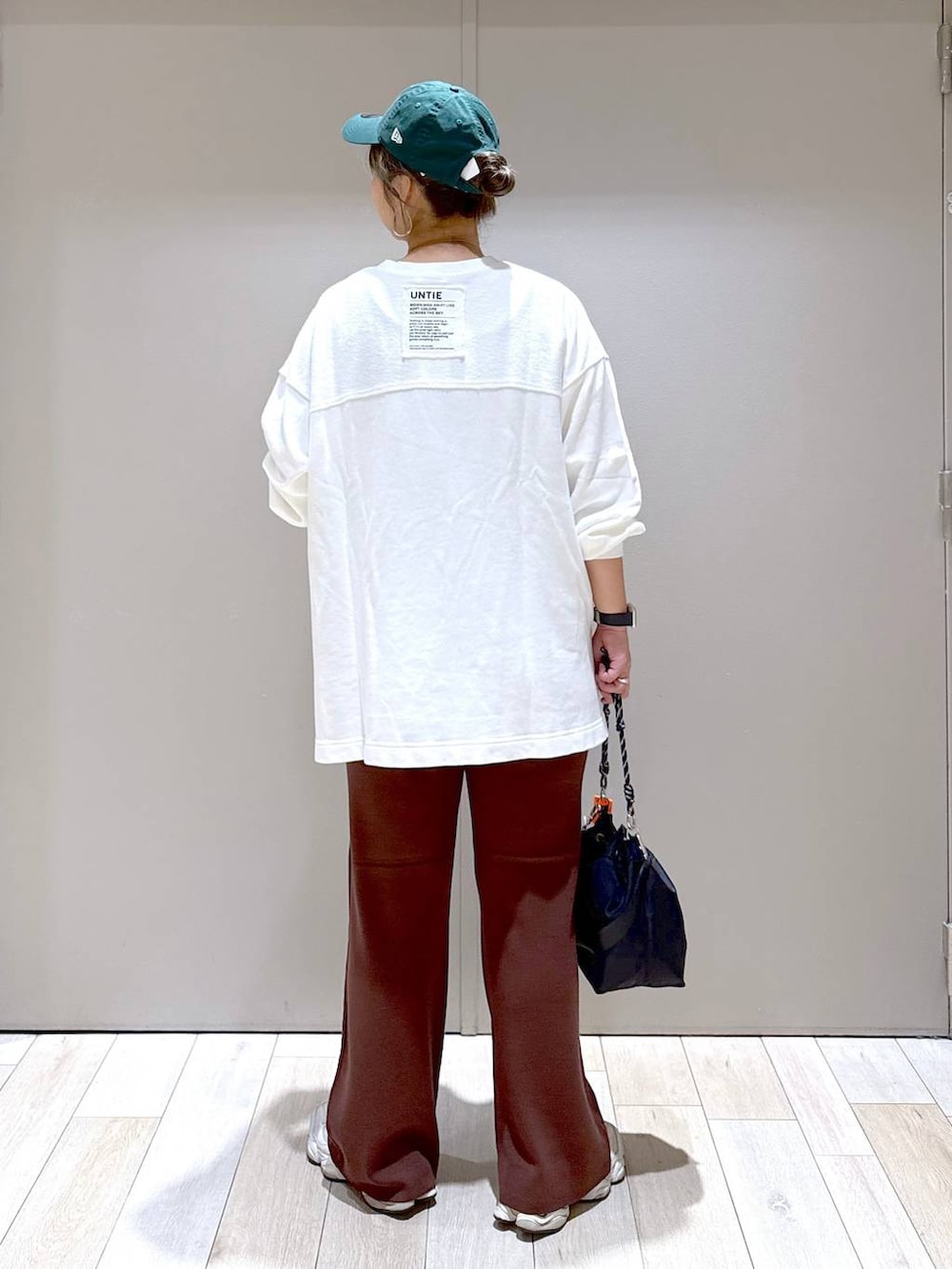 ブラック系のショルダーバッグ、ホワイト系のTシャツ/カットソー、ブラウン系のマタニティウェア/グッズを着用したレディースの秋コーディネートの3枚目の写真