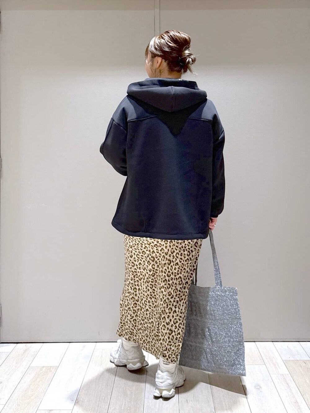 シルバー系のトートバッグ、ブラック系のブルゾン、その他のスカートを着用したレディースの冬コーディネートの3枚目の写真