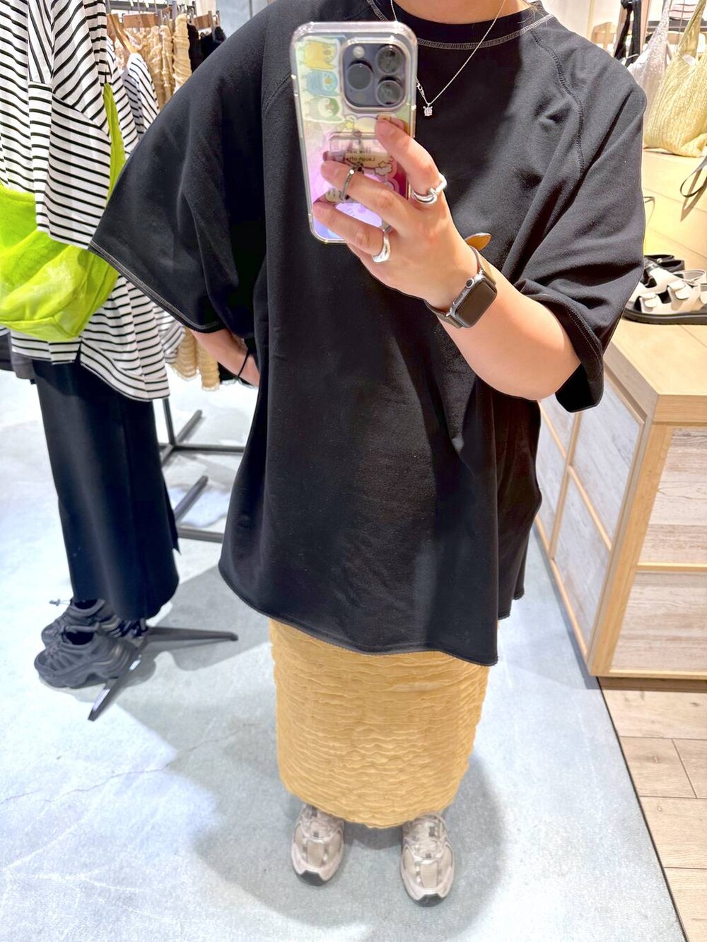 ベージュ系のスカート、ブラック系のTシャツ/カットソーを着用したレディースの春コーディネートの2枚目の写真