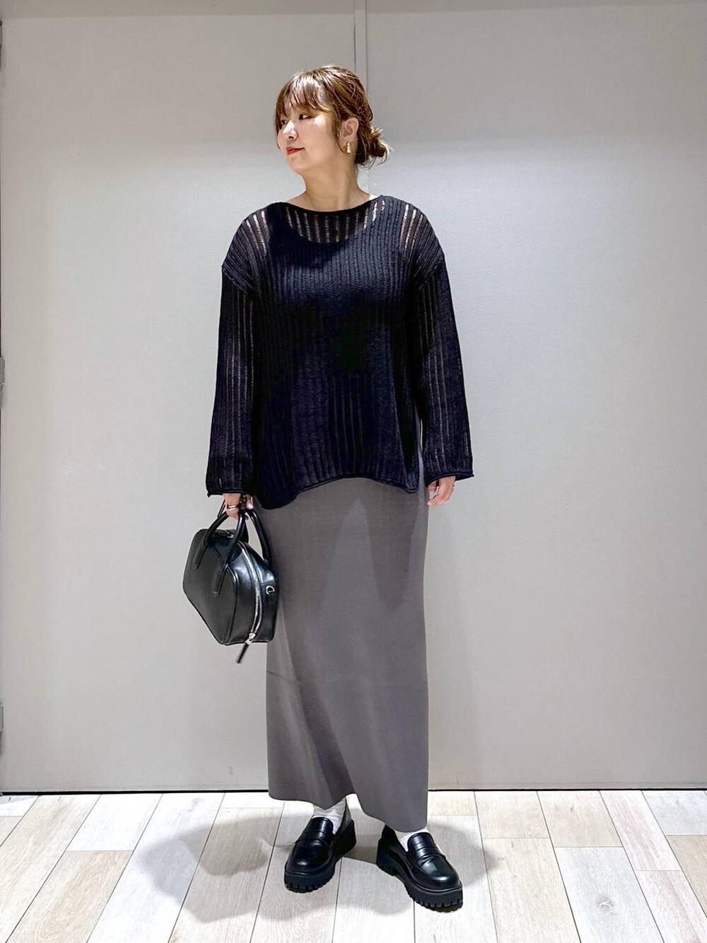 ブラック系のニット/セーター、ブラック系のボストンバッグ、ブラック系のローファーを着用したレディースの秋コーディネートの5枚目の写真