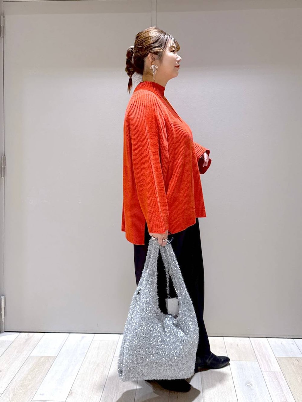 シルバー系のショルダーバッグ、ブラック系のその他パンツ、ブラック系のブーツを着用したレディースの冬コーディネートの2枚目の写真