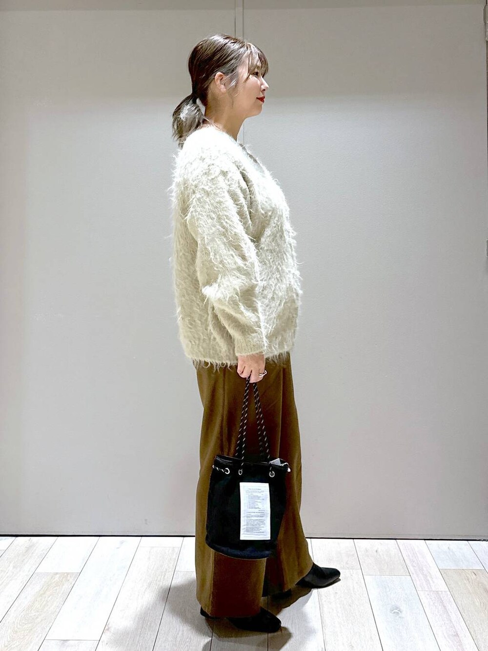 ブラック系のブーツ、ブラウン系のその他パンツ、ベージュ系のカーディガン/ボレロを着用したレディースの秋コーディネートの2枚目の写真