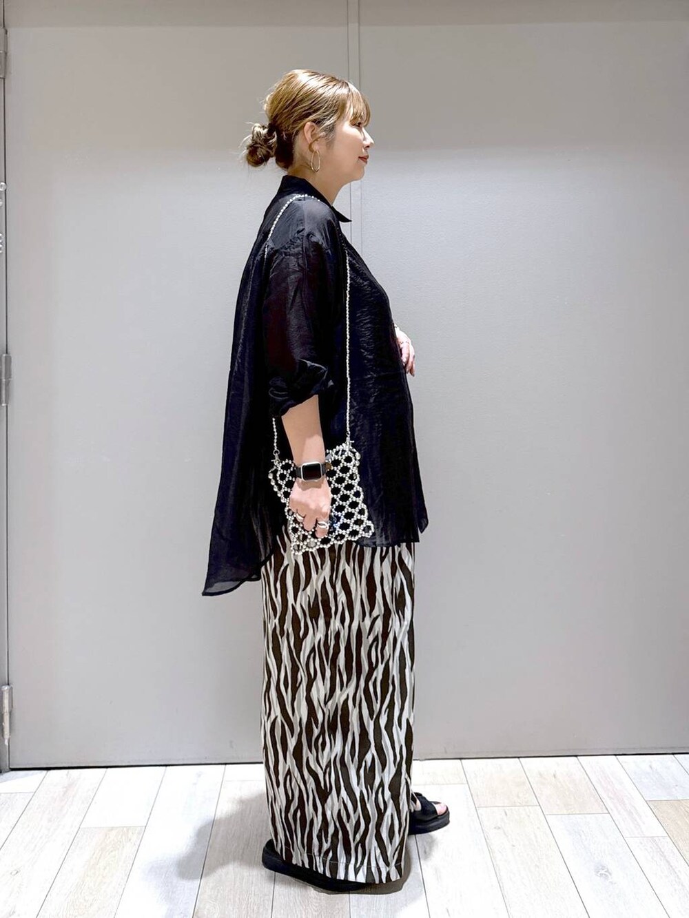 ブラック系のサンダル、シルバー系のショルダーバッグ、ブラック系のシャツ/ブラウスを着用したレディースの夏コーディネートの2枚目の写真